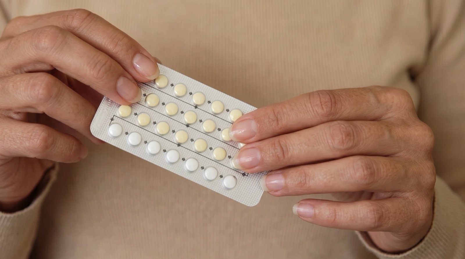 A woman holding a packet of the contraceptive pill