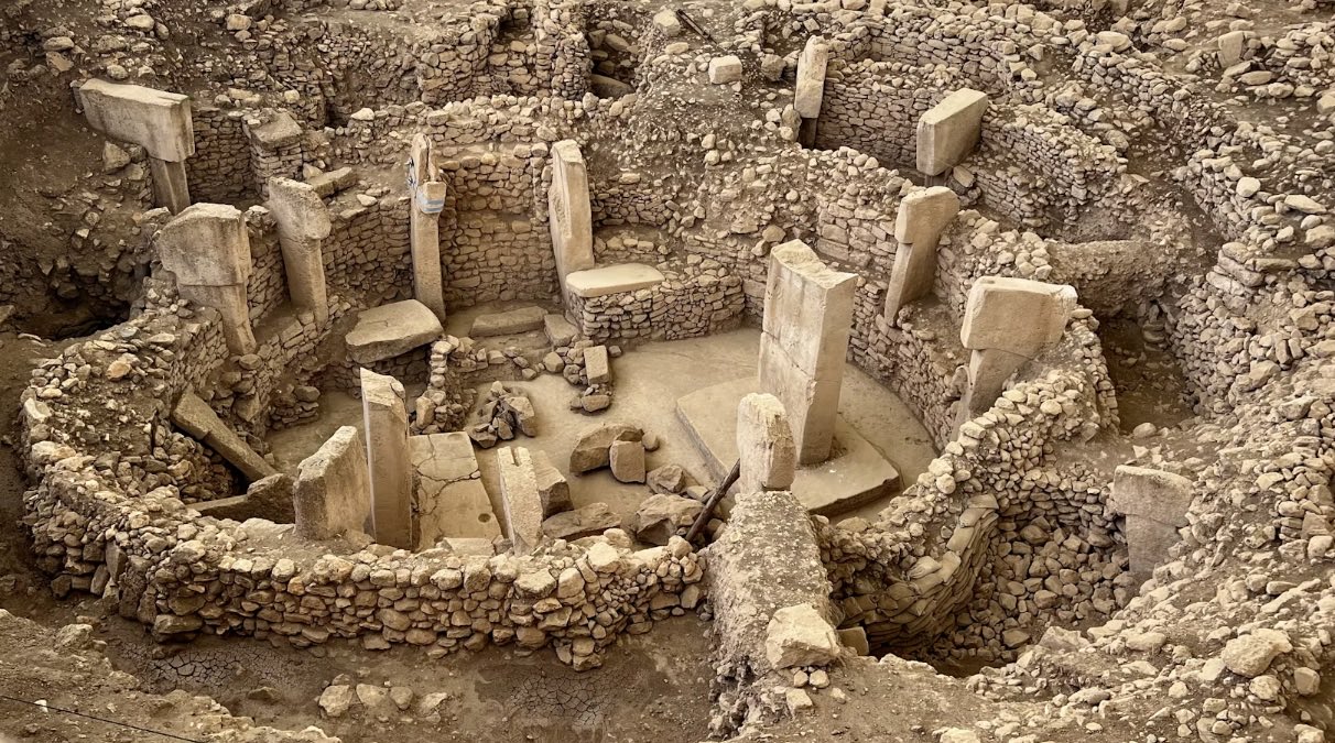 Excavated stone circles at Gobekli Tepe in Turkiye, T-shaped limestone pillars standing inside curved dry stone walls