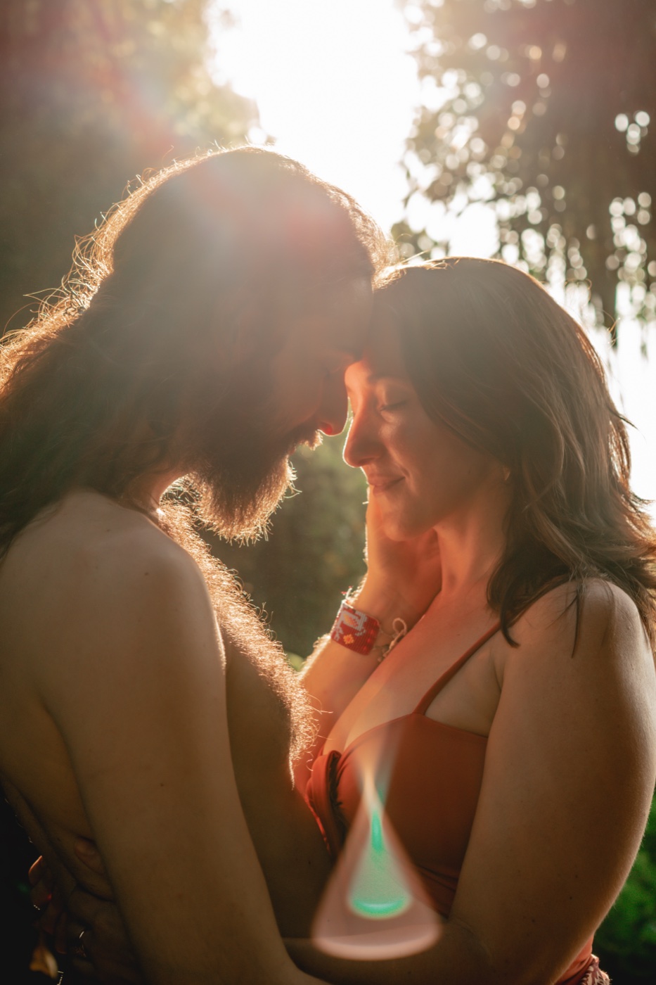 Jodie Louise and her partner forehead to forehead in golden light